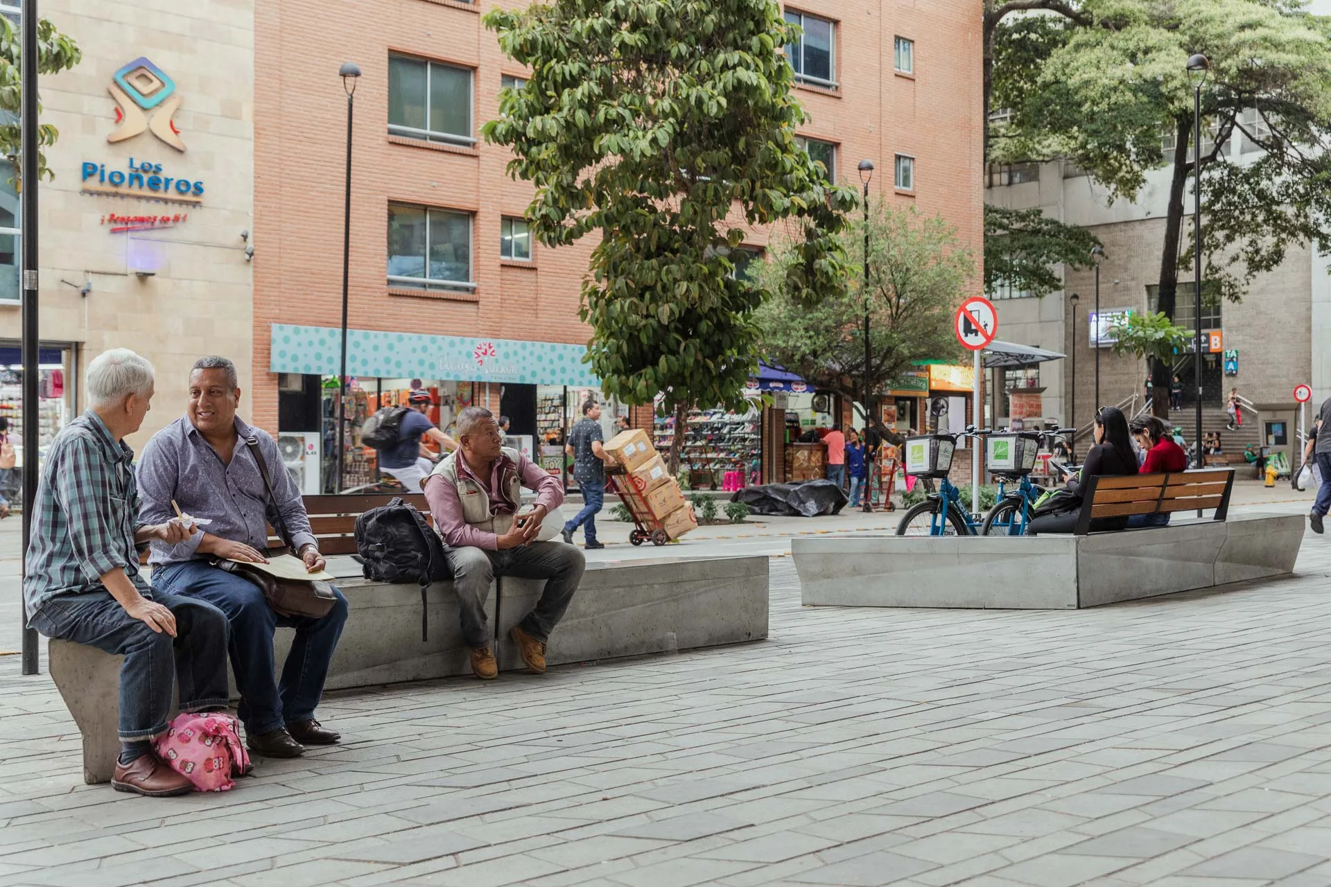 Ciudadanos descansando en las zonas comunes de la Renovación del Centro de Medellín.